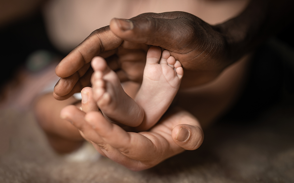 Interracial,Family,Holding,Baby,Feet,In,Hands,Mixed,By,Black